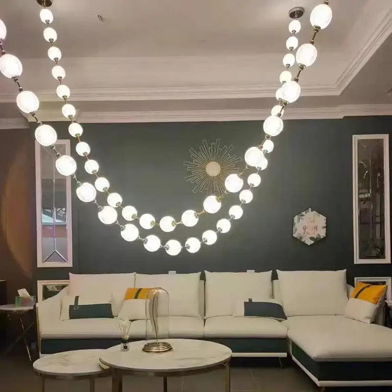 Elegant crystal and gold pendant lights featuring a modern multi-tiered chandelier with white glass spherical bulbs for decorbites elegant pendant decor