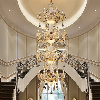 A decorbites elegant crystal gold tiered chandelier with clear crystal droplets above a grand staircase