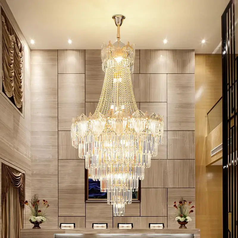 Elegant crystal duplex chandelier with cascading clear and gold glass prisms suspended from polished brass decorbites elegant crystal fixture