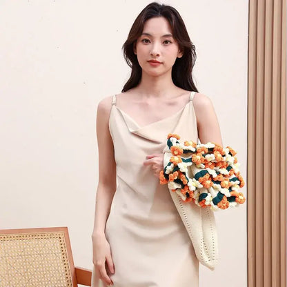 A crocheted clutch bag with vibrant orange white and teal floral clusters on a cream base decorbites elegant daisy bouquet