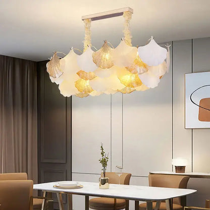 A modern decorbites ginkgo gold led chandelier with translucent white and gold leaf-shaped shades for living room light