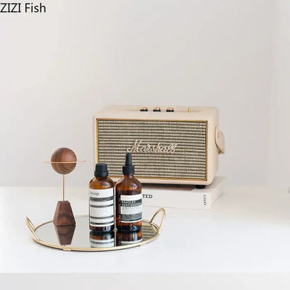 Cream-colored marshall speaker with textured grille and gold-tone accents on decorbites brass handle storage tray