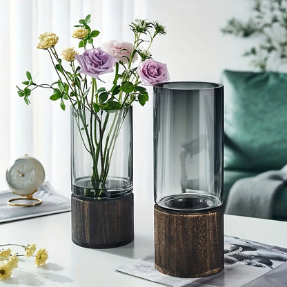 Elegant glass vase with dark wood base holding purple and yellow flowers for modern hydroponic home decoration