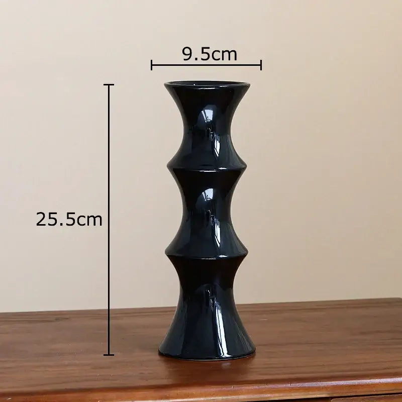 A sleek glossy black decorbites bamboo ceramic vase with a tiered hourglass silhouette for living room decor