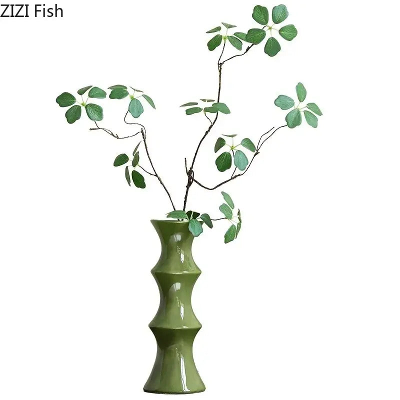 Elegant glossy black decorbites bamboo ceramic vase with bamboo-inspired segmented design holding green leafy branches