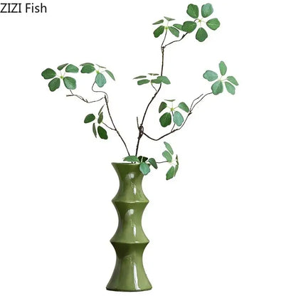 Elegant glossy black decorbites bamboo ceramic vase with bamboo-inspired segmented design holding green leafy branches