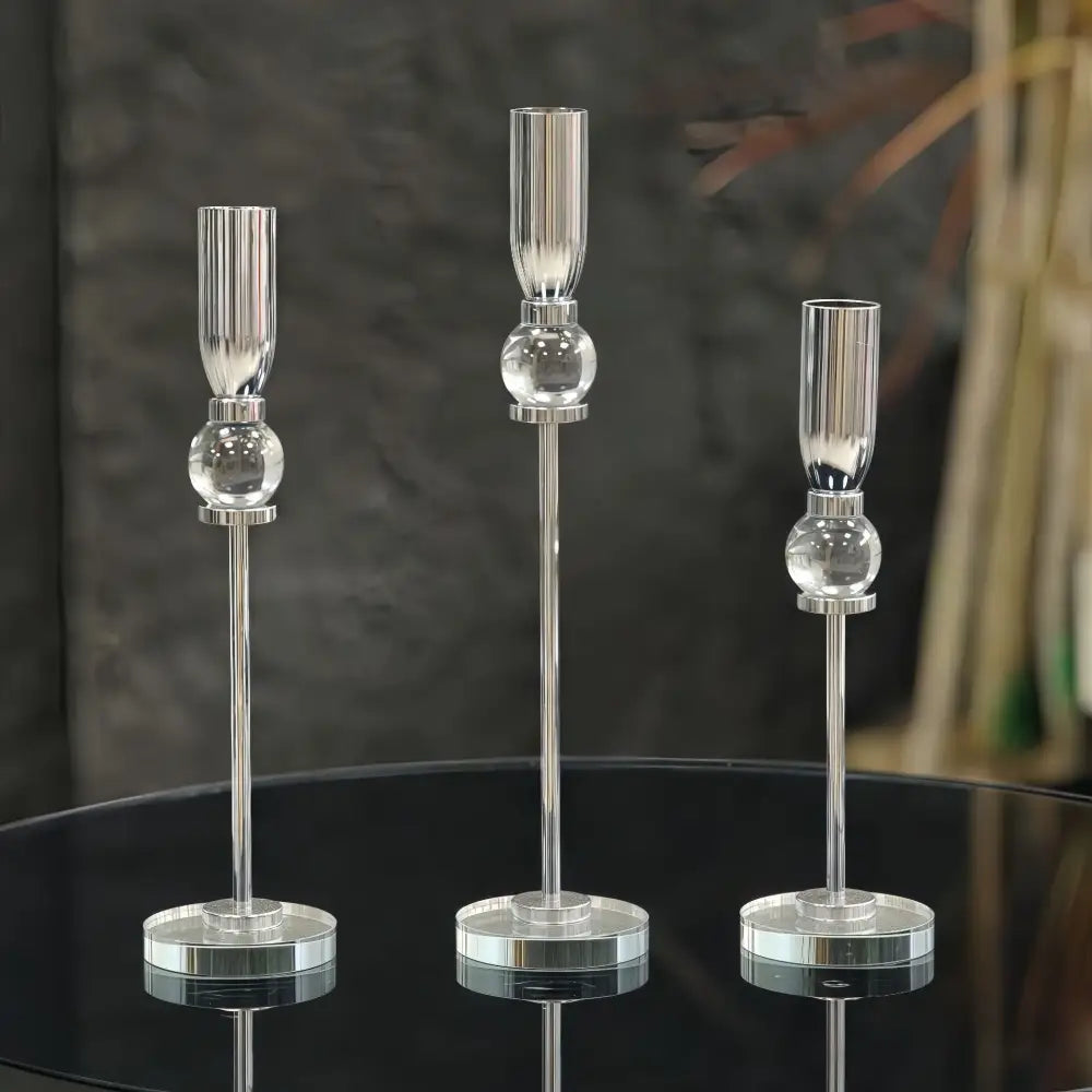 Three elegant crystal glass candlestick holders with sleek silver stems and spherical glass accents for dining room decorbites