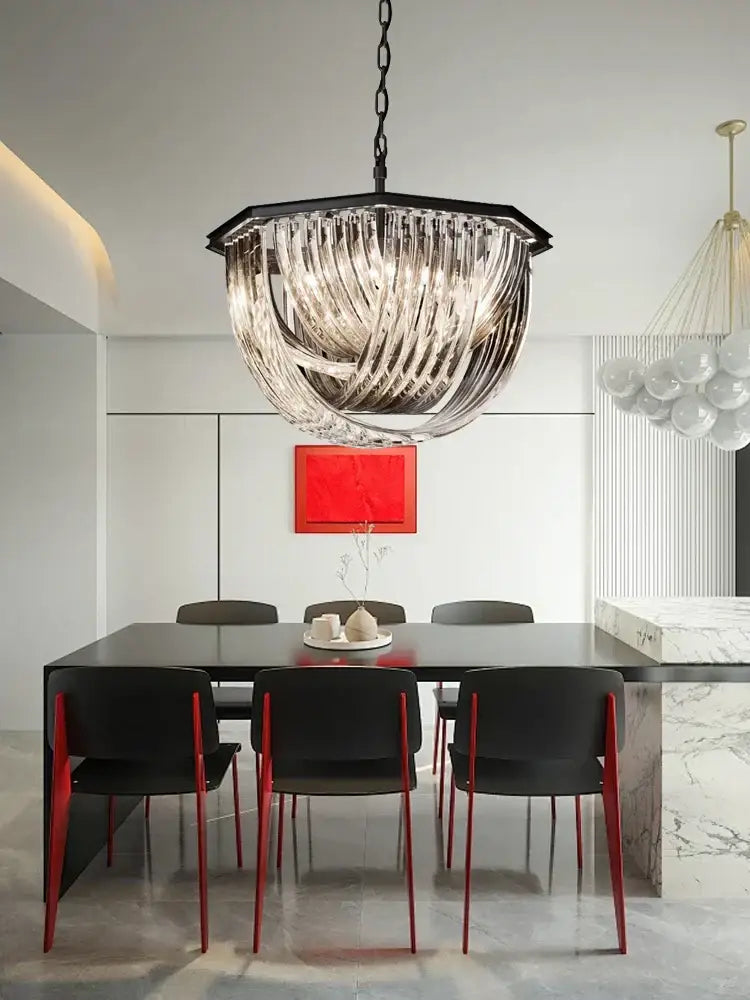A modern black metal pendant light with geometric frame and cascading clear glass ribbons for kitchen islands