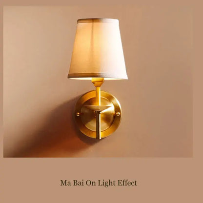 A warm-toned brass wall lamp with a tapered cream fabric shade ideal for elegant bedroom decorbites copper wall lamp