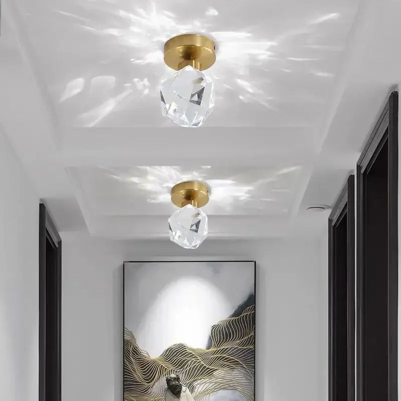 Two crystal pendant ceiling light fixtures with gold-finished bases for elegant hallway entrance lighting