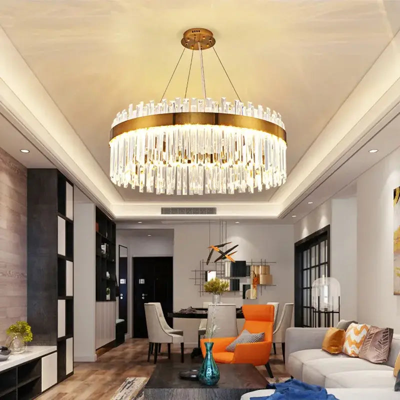 A modern elegant crystal chandelier pendant light with a gold-toned frame and cascading clear crystal rods for dining room decor