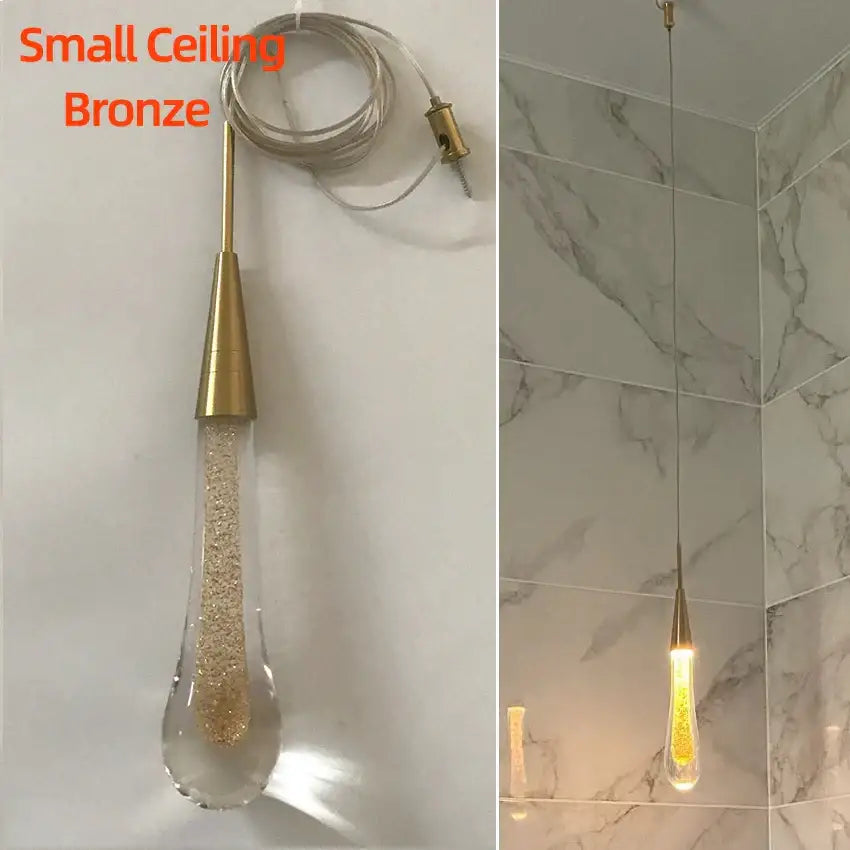 A small bronze pendant light with a teardrop crystal glass led shade filled with golden glitter for dining room decor