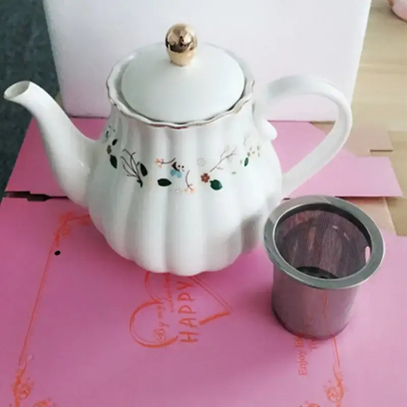White ceramic teapot with gold-toned knob and floral decals with stainless steel infuser for decorbites elegant gold saucer set