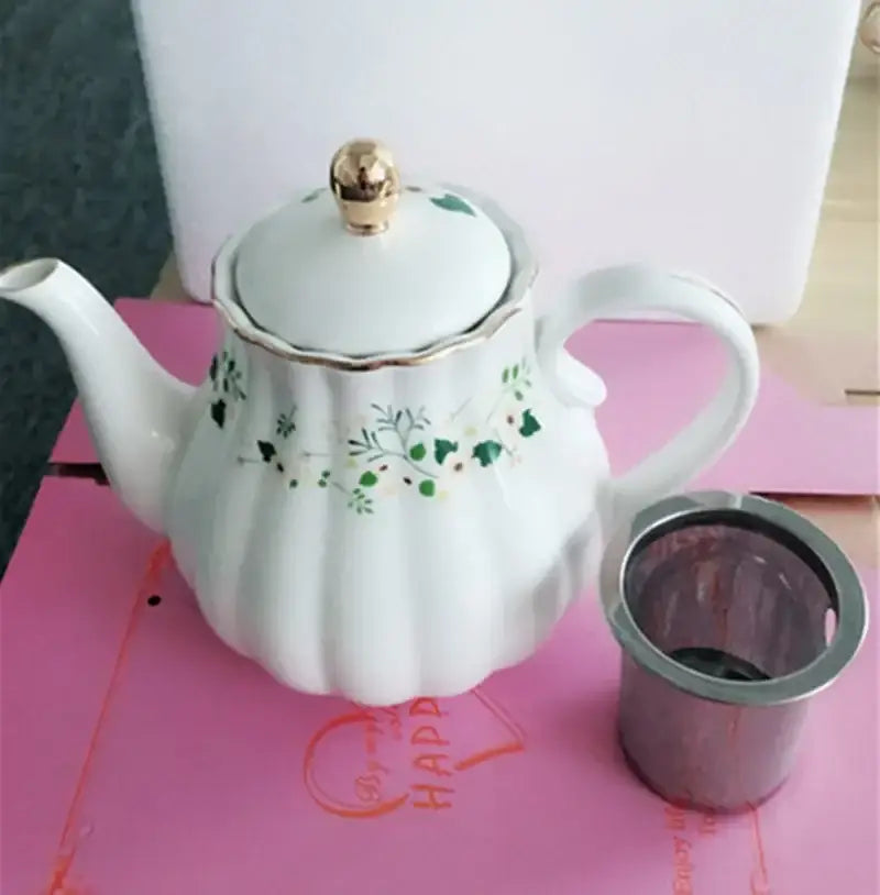 White ceramic teapot with green floral patterns gold trim and fluted body in a decorbites elegant gold flower saucer set