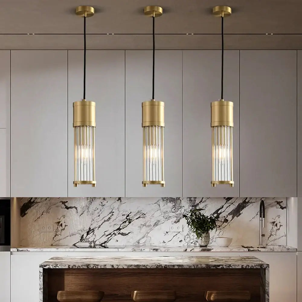 Three elegant gold-toned glass shade pendant lights with clear rods for kitchen and dining room lighting