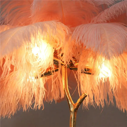 Elegant gold ostrich feather floor lamp with a branch-like stand, soft white feathers, and warm lighting decorbites elegant ostrich