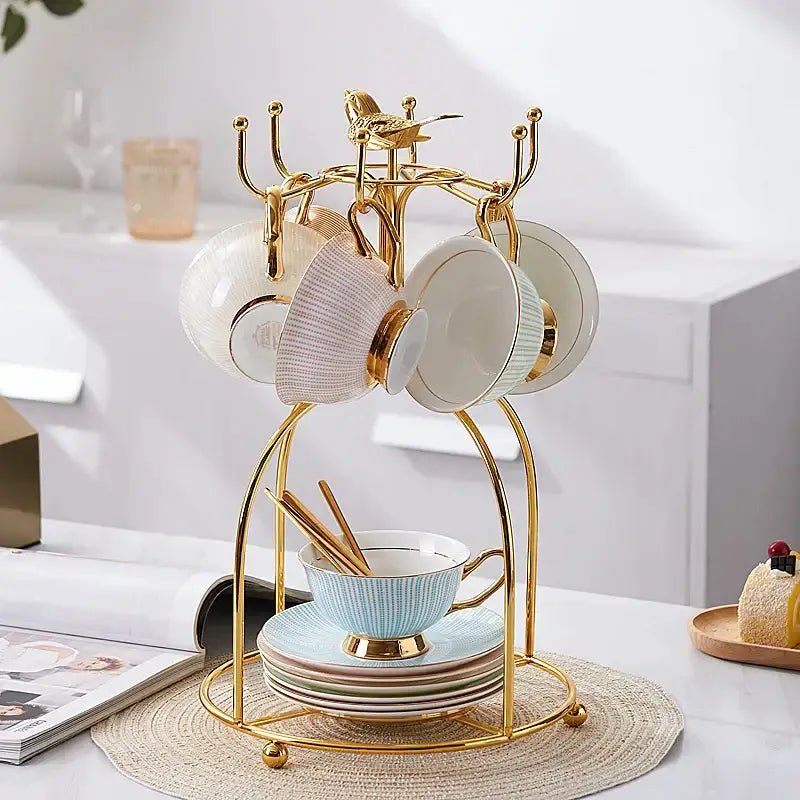 Elegant gold porcelain tea set dining room rack with bird figurine holding pastel blue white and beige ceramic teacups