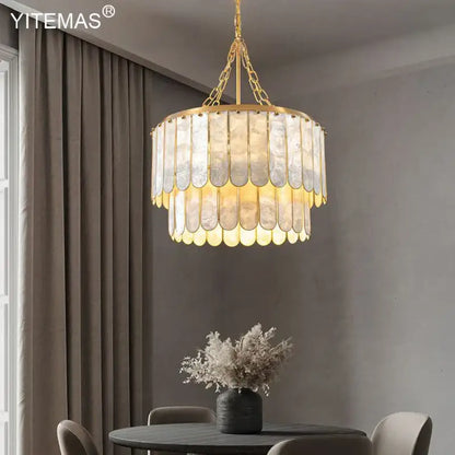 Elegant gold shell chandelier with layered translucent shell panels hanging from a chain by decorbites gold shell decor