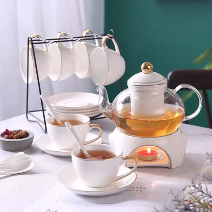 White ceramic glass teapot with gold accents on a white electric warmer base from decorbites gold white tea set