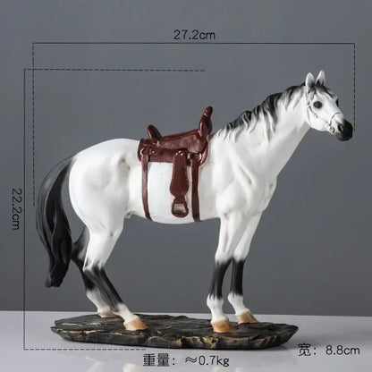 Elegant horse resin statue featuring a white and black horse with a brown saddle on a rocky base for living room decor