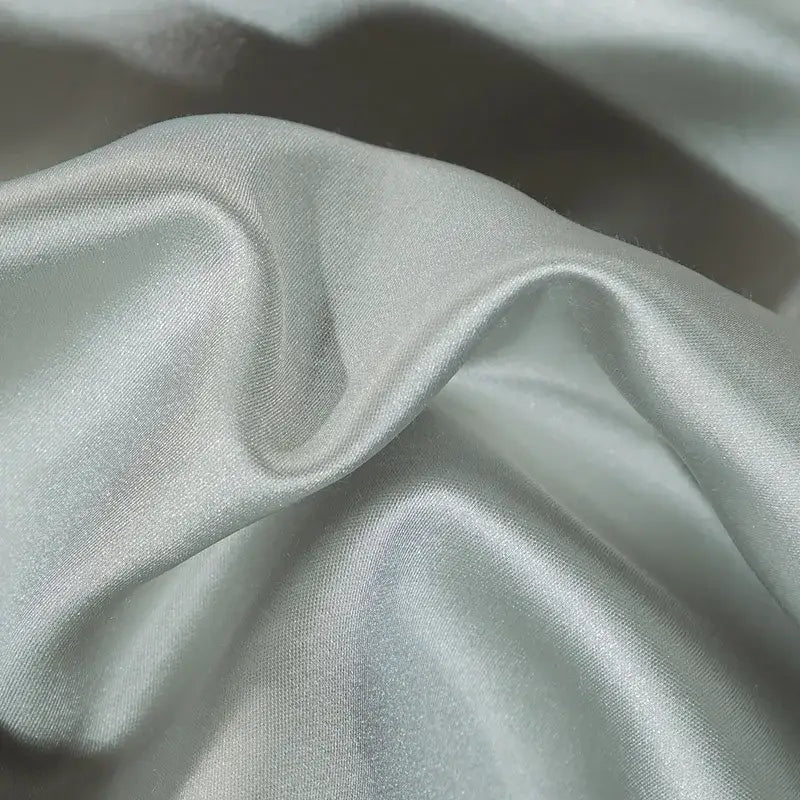 Soft pale green satin fabric with glossy finish and folds in elegant ivory royal blue 200s embroidery egyptian cotton bedding set