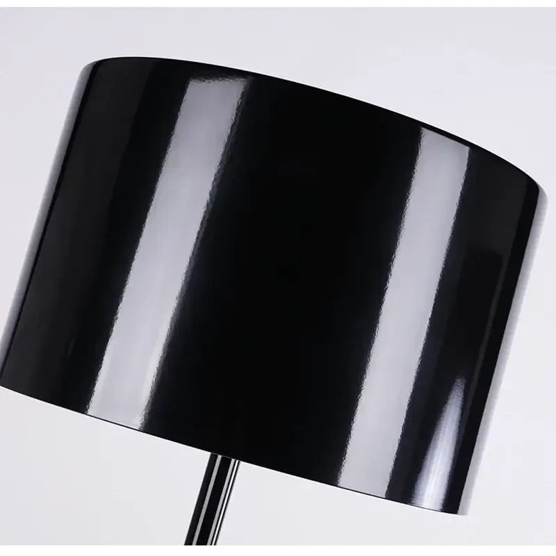 Black glossy cylindrical lampshade on decorbites elegant mushroom floor lamp providing warm glow for living room decor