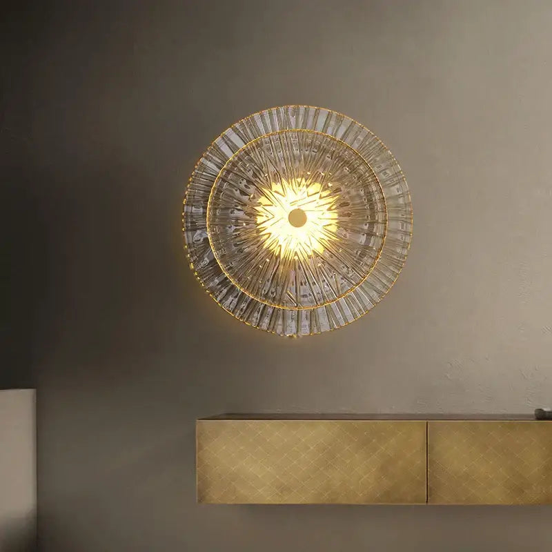 A radiant circular wall sconce with golden frame and ribbed glass segments for living room decorbites elegant glass wall