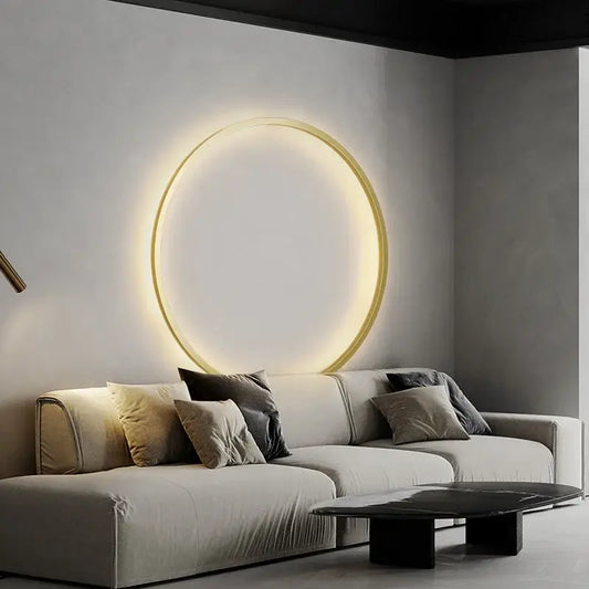 A sleek decorbites elegant round wall sconce with a warm glow and thin gold-toned frame for bedroom lighting
