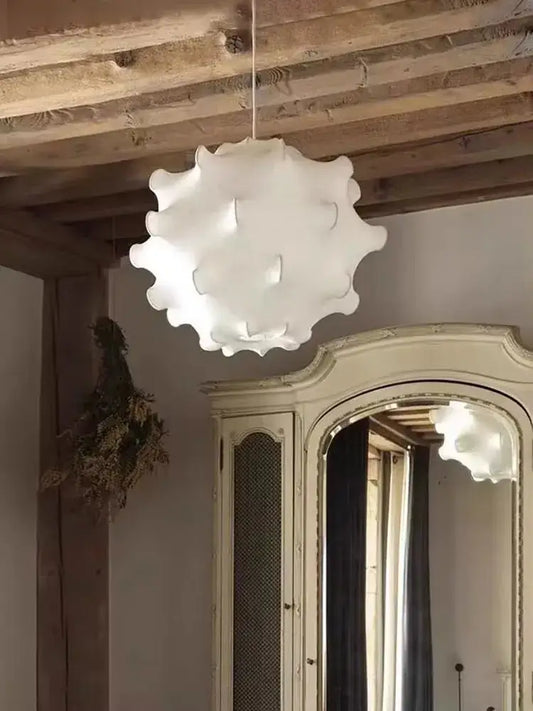 A white elegant silk pendant lamp with ruffled petal design hanging in a living room by decorbites elegant silk pendant