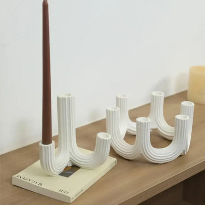 Elegant white ceramic candlestick holder with vertical ridged texture and curved u-shaped arms for dining room decorbites elegant white decor