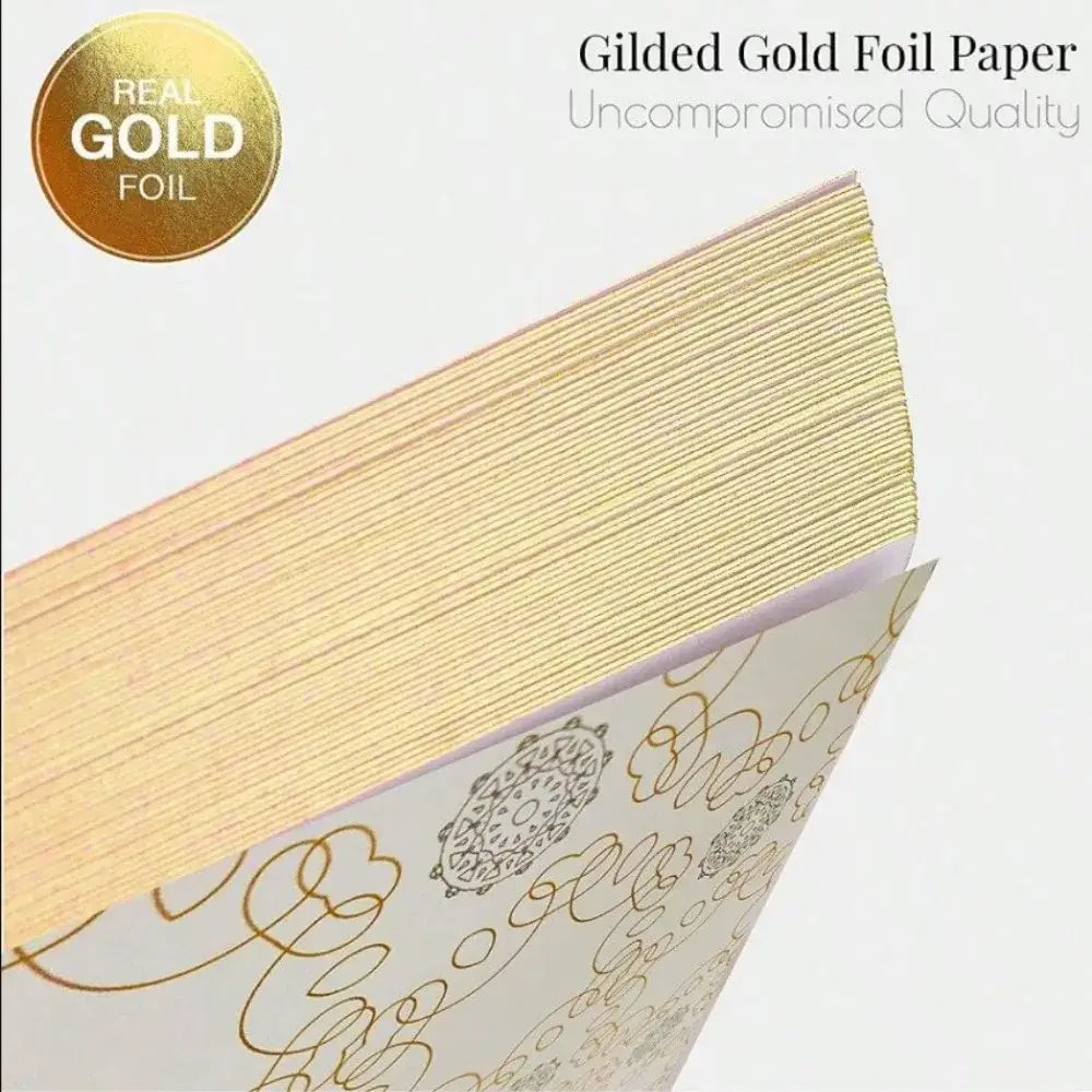 Stack of gilded gold foil paper with intricate bronzing designs on white surface decorbites guest book decor