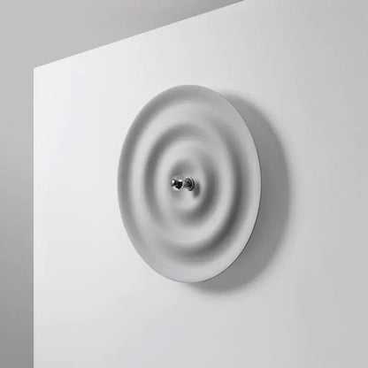 Elegant white ripple led wall sconce featuring minimalist ceramic design with concentric ridges and chrome knob for decorbites elegant led wall decor