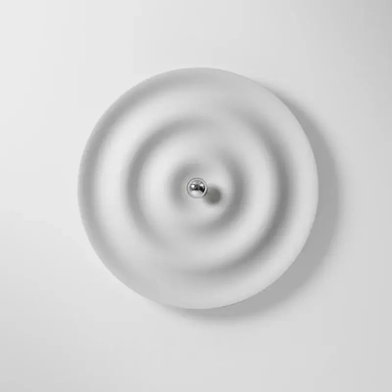 Minimalist white ceramic wall sconce with concentric ridges and central metallic sphere for decorbites elegant led wall use