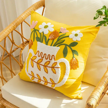 Bright yellow cushion cover with white embroidered vase flower design featuring colorful flowers and green leaves decorbites elegant yellow
