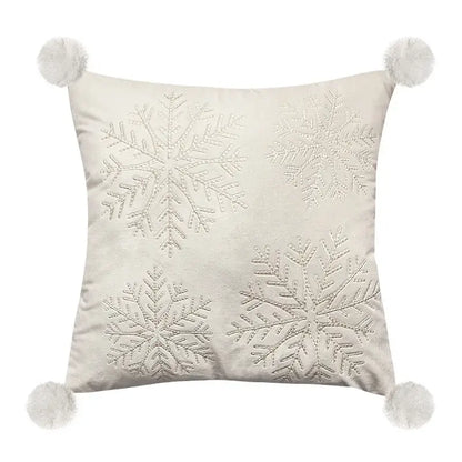 Cream-colored pillow cover with four embroidered silver snowflakes and white pom-poms for decorbites embroidered christmas decor