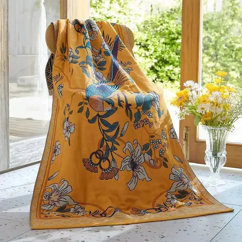 A vibrant yellow silk scarf with blue and white birds complements embroidered cream fruit decorbites cotton gauze bath towels