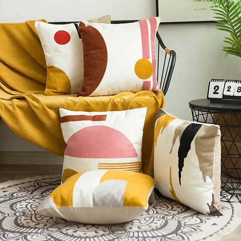 A cozy mustard-yellow throw blanket draped over a black metal chair paired with an embroidered cushion cover set