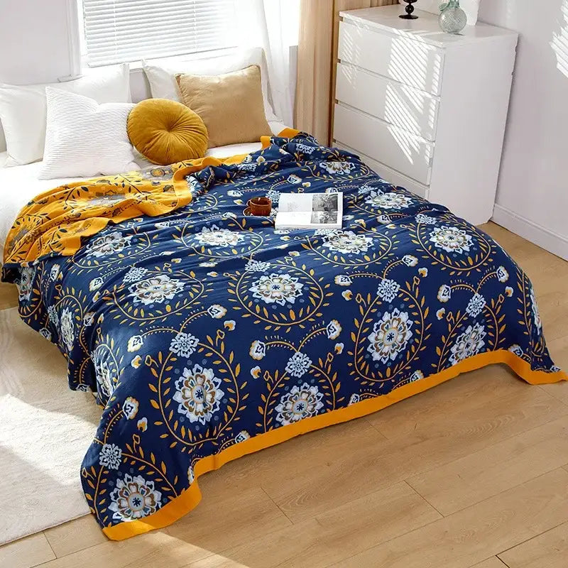 A cozy navy blue and gold floral-patterned decorbites cotton gauze bedroom blanket with soft plush texture