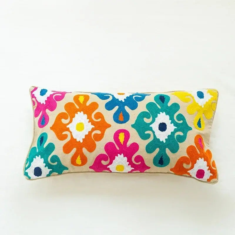 Vibrant embroidered flower boho cushion cover with bold orange pink teal and yellow floral patterns on beige fabric