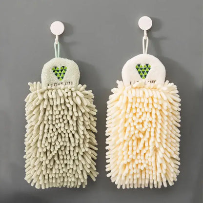 Two hanging embroidered microfiber hand towels in pale green and cream with a green heart design for kitchen decor