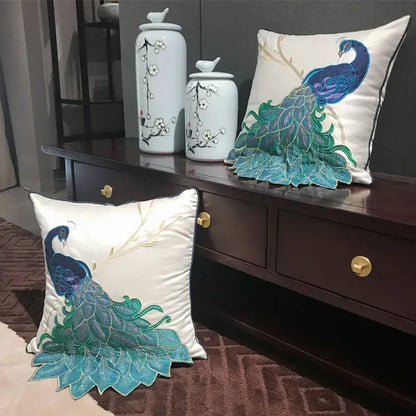 Cream satin cushion cover with embroidered peacock design in blue and teal for living room decor