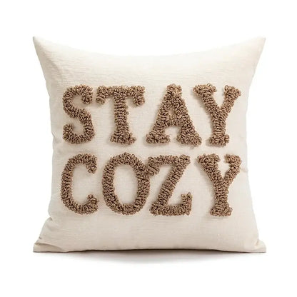 Cream-colored throw pillow with stay cozy embroidered in beige yarn as part of decorbites cartoon christmas pillow covers