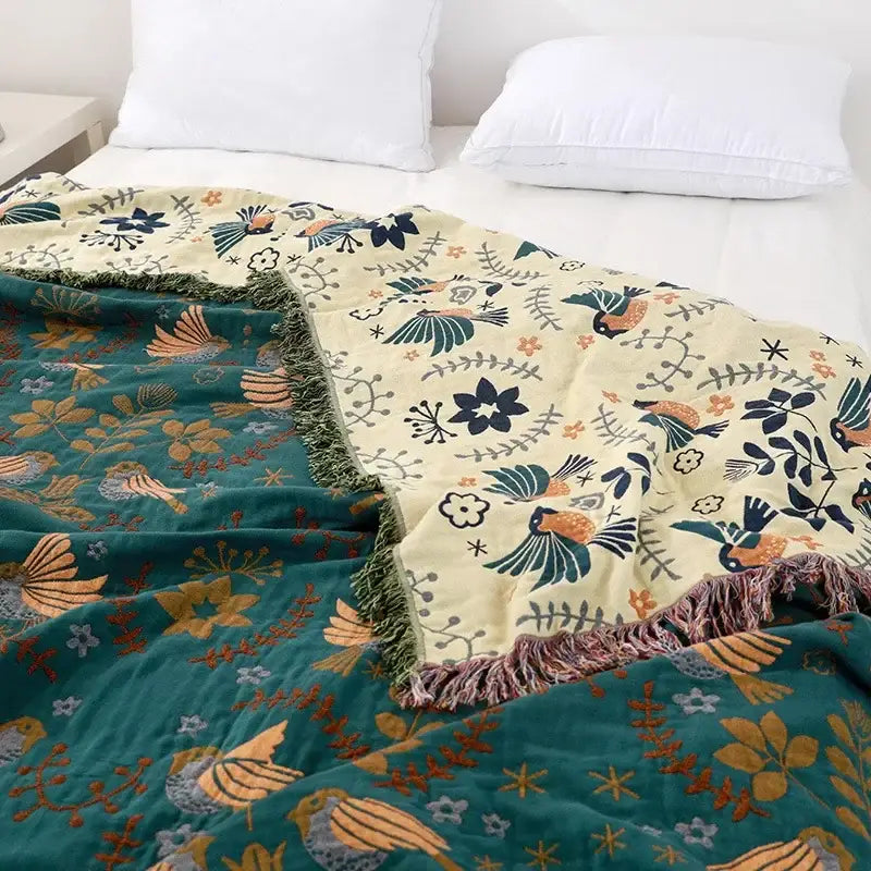 Cozy embroidered teal and cream cotton sofa throw blanket with vibrant bird floral pattern and fringed edges for living room