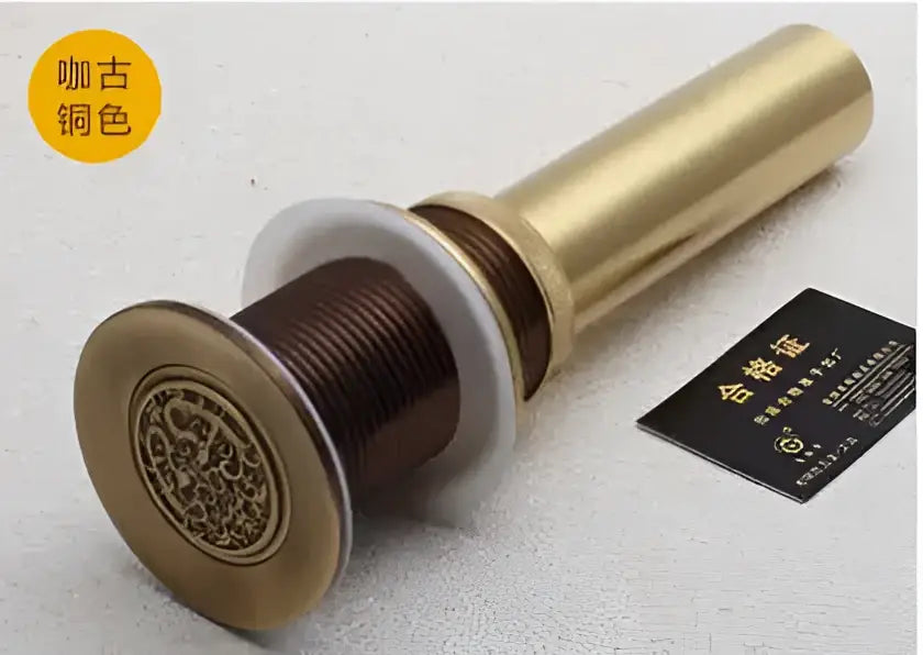Ornately engraved brass bathroom sink pop up drain stopper with cylindrical body and threaded base for decorbites brass bathroom use