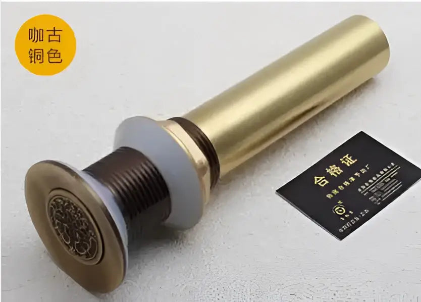 Engraved brass bathroom sink pop up drain stopper in copper-toned brass with ornate circular design and threaded body