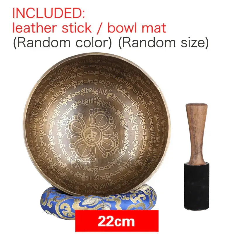 A 22cm engraved gold bronze tibetan singing bowl with sanskrit script and floral design, with wooden mallet for meditation