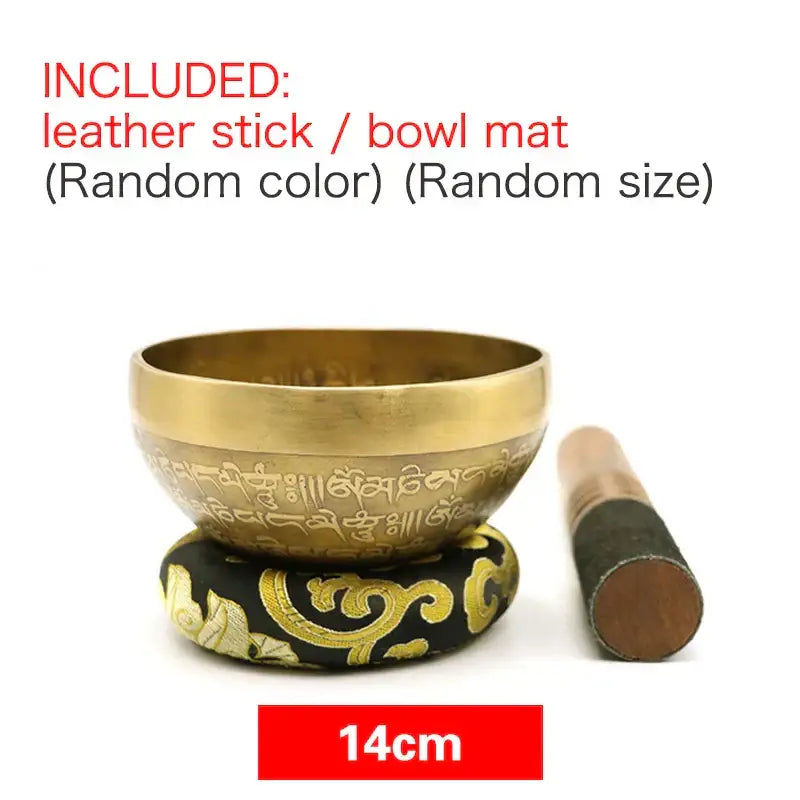 Engraved gold tibetan singing bowl with intricate script on a black and gold leather mat for yoga meditation decor