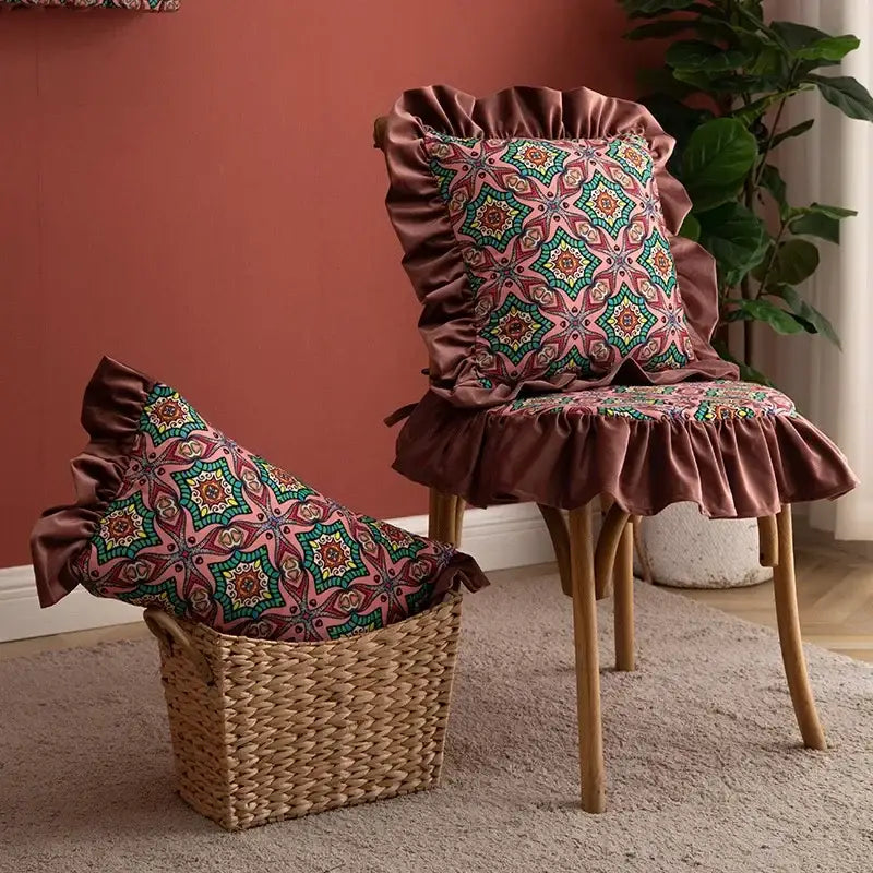 A plush mauve chair cover with ruffled edges and geometric teal and gold accents complements an ethnic pillow cover set