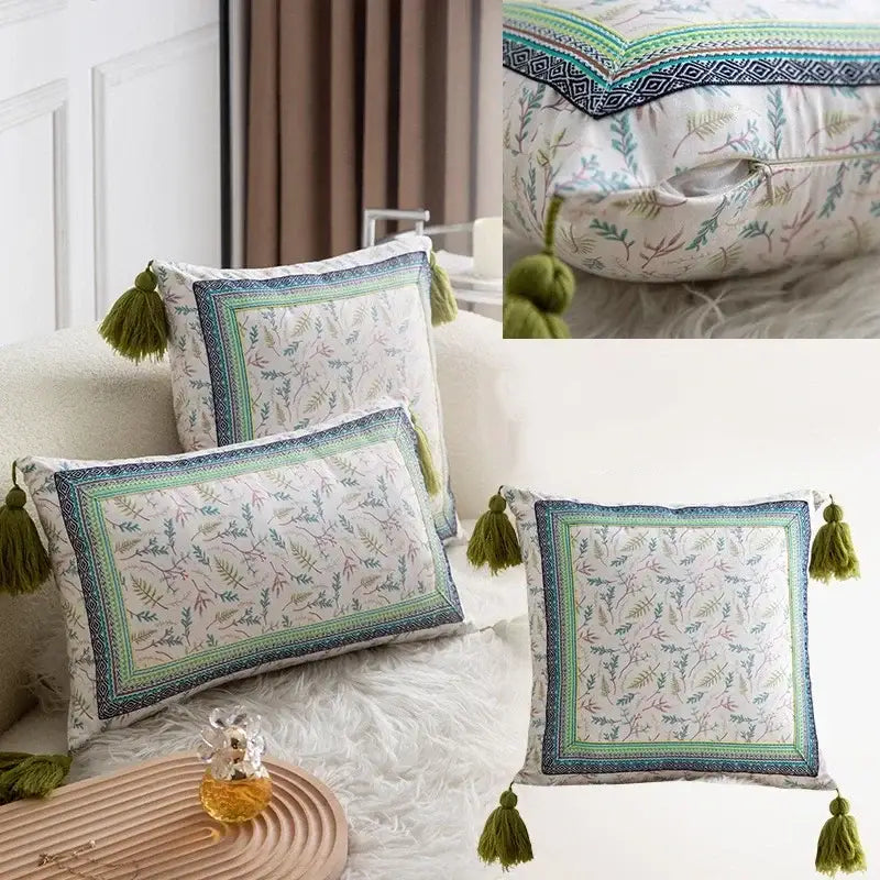 Square pillow cover set with white base, ethnic botanical teal and navy print, geometric borders, and olive-green tassels