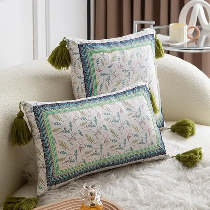Two rectangular pillow covers with ethnic botanical print and olive green tassels in teal and navy cover set